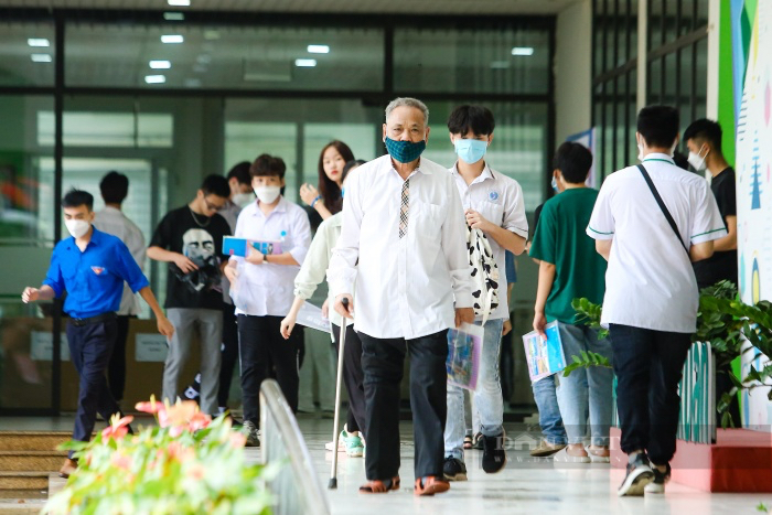 Cụ ông Nguyễn Huy Kỳ cùng các sĩ tử bước ra khỏi điểm thi Trường THCS Thanh Xuân sáng ngày 8/7 vừa qua.